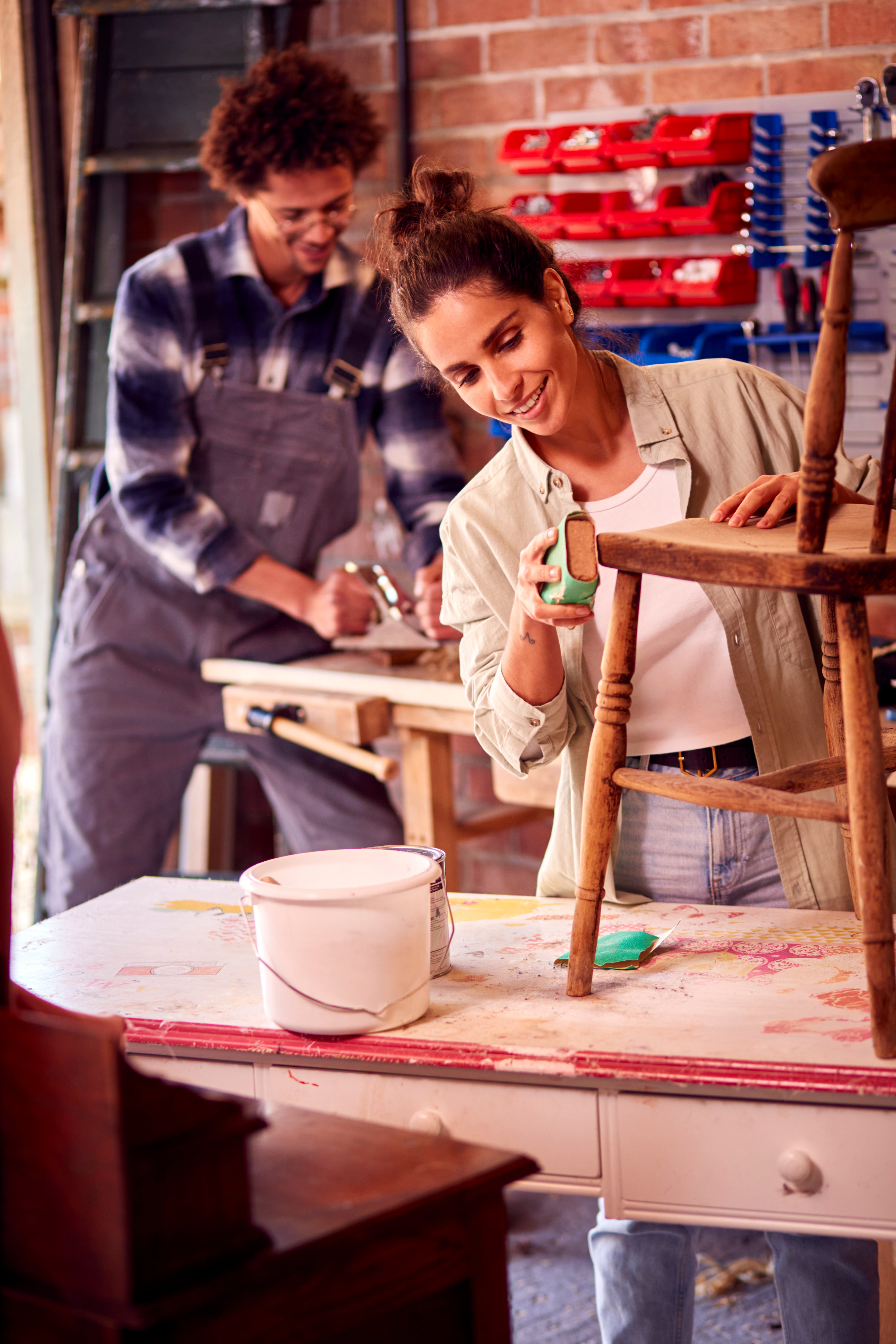 Couple enjoying DIY project in a workshop, using premium paints and decorative stencils for creative home décor upgrades.