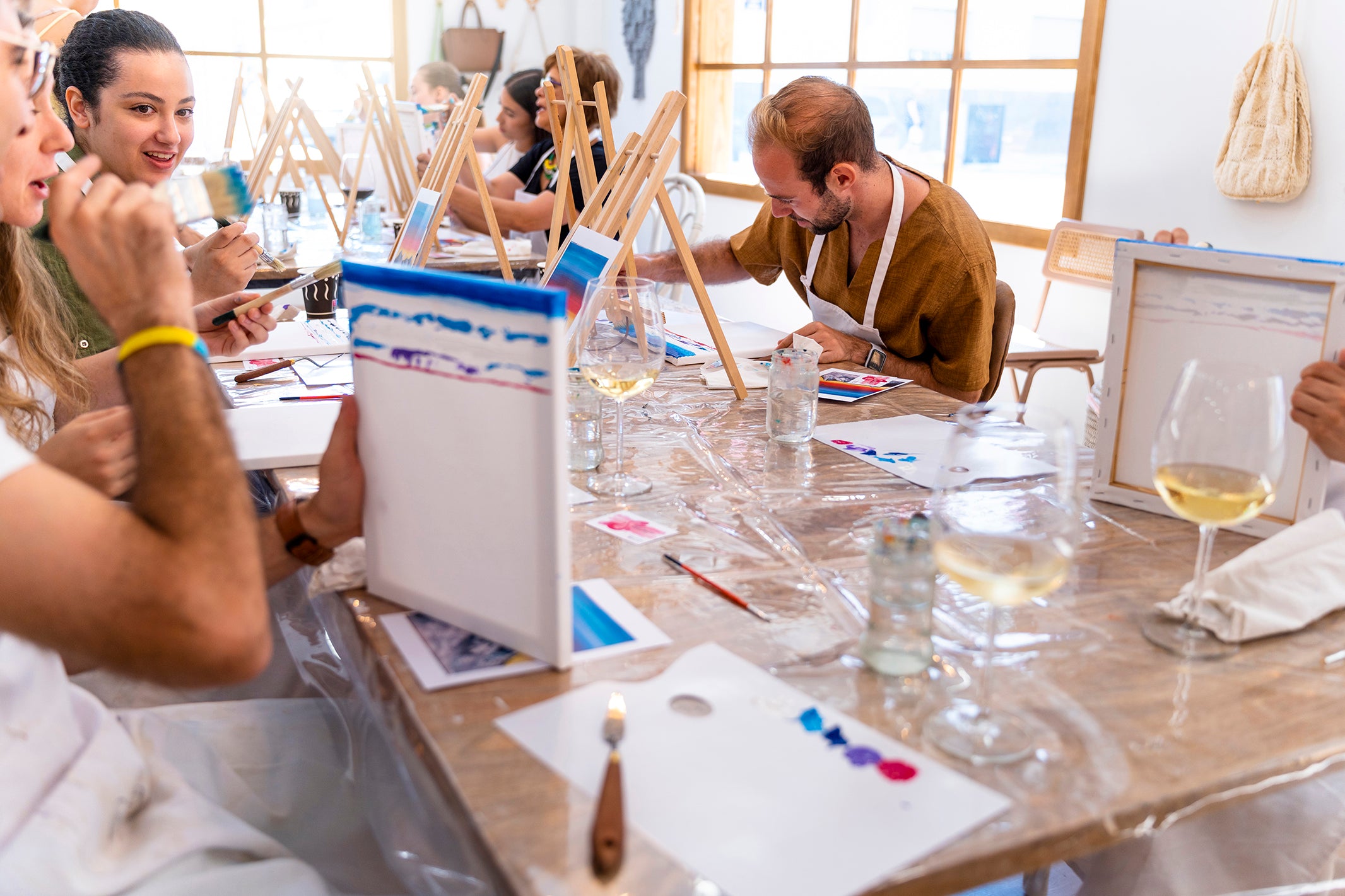 Group enjoying a DIY painting class with premium paints and art tools, creating wall stencils and craft designs for home décor.