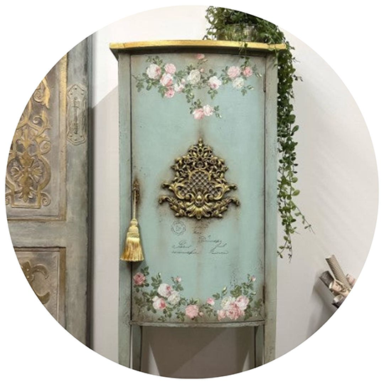 Vintage blue cabinet adorned with floral stencils, showcasing premium paints and unique home décor accessories.