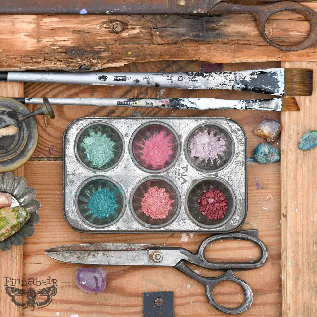 Mica Powder Set, Vintage in metal tin with art tools, including paint brushes and scissors on wooden table.