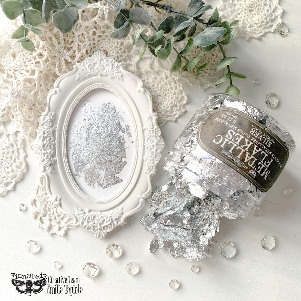 Fine Mica Flakes, Silver in a jar next to a decorative frame, ideal for DIY décor and artistic finishes.